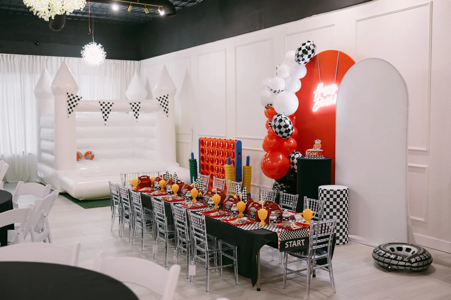 Decorated event space with seating, bounce house, and games for a kids themed birthday party at Aramas Events