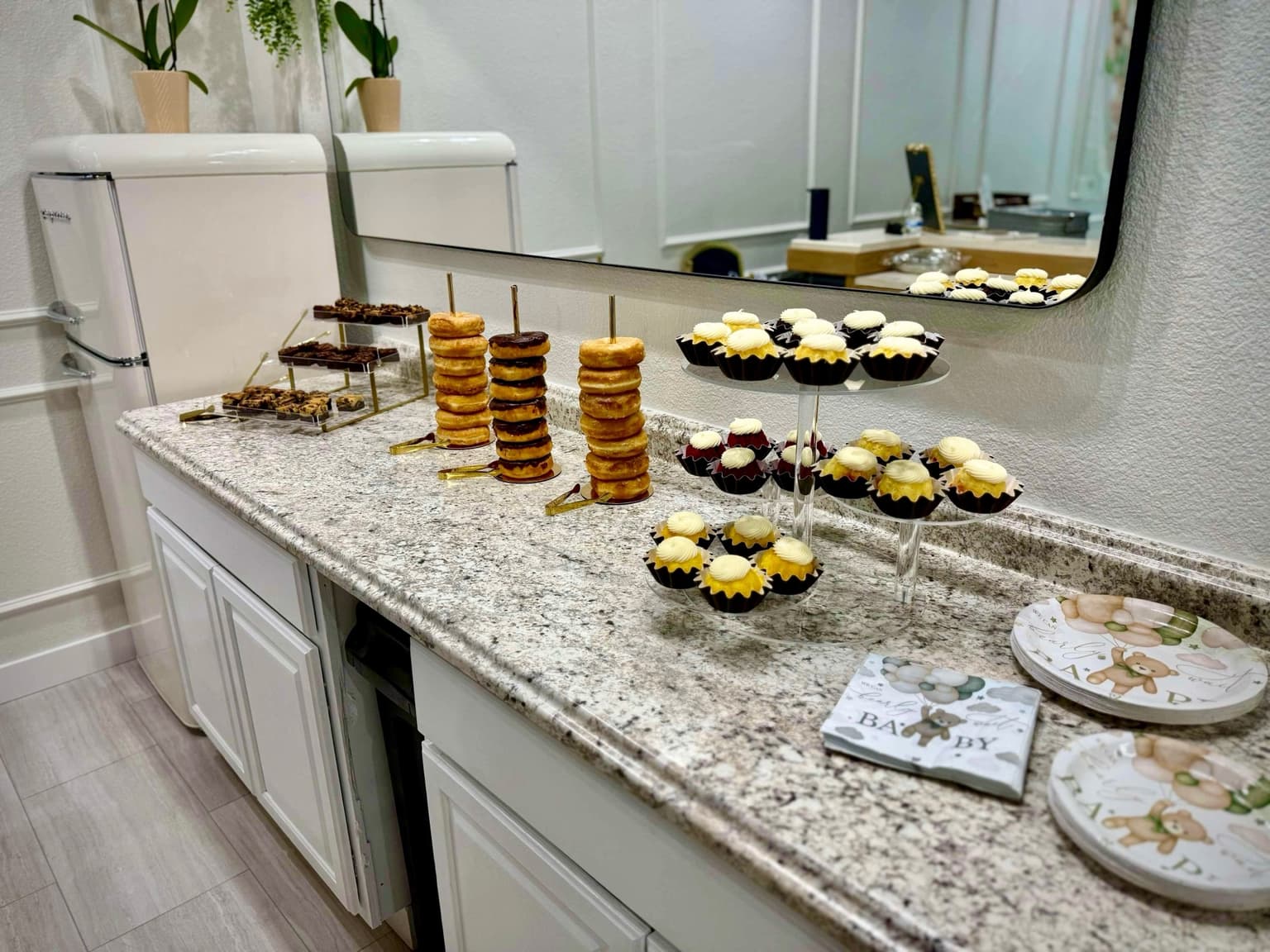 Dessert display with cupcakes and treats for a baby shower at Aramas Events