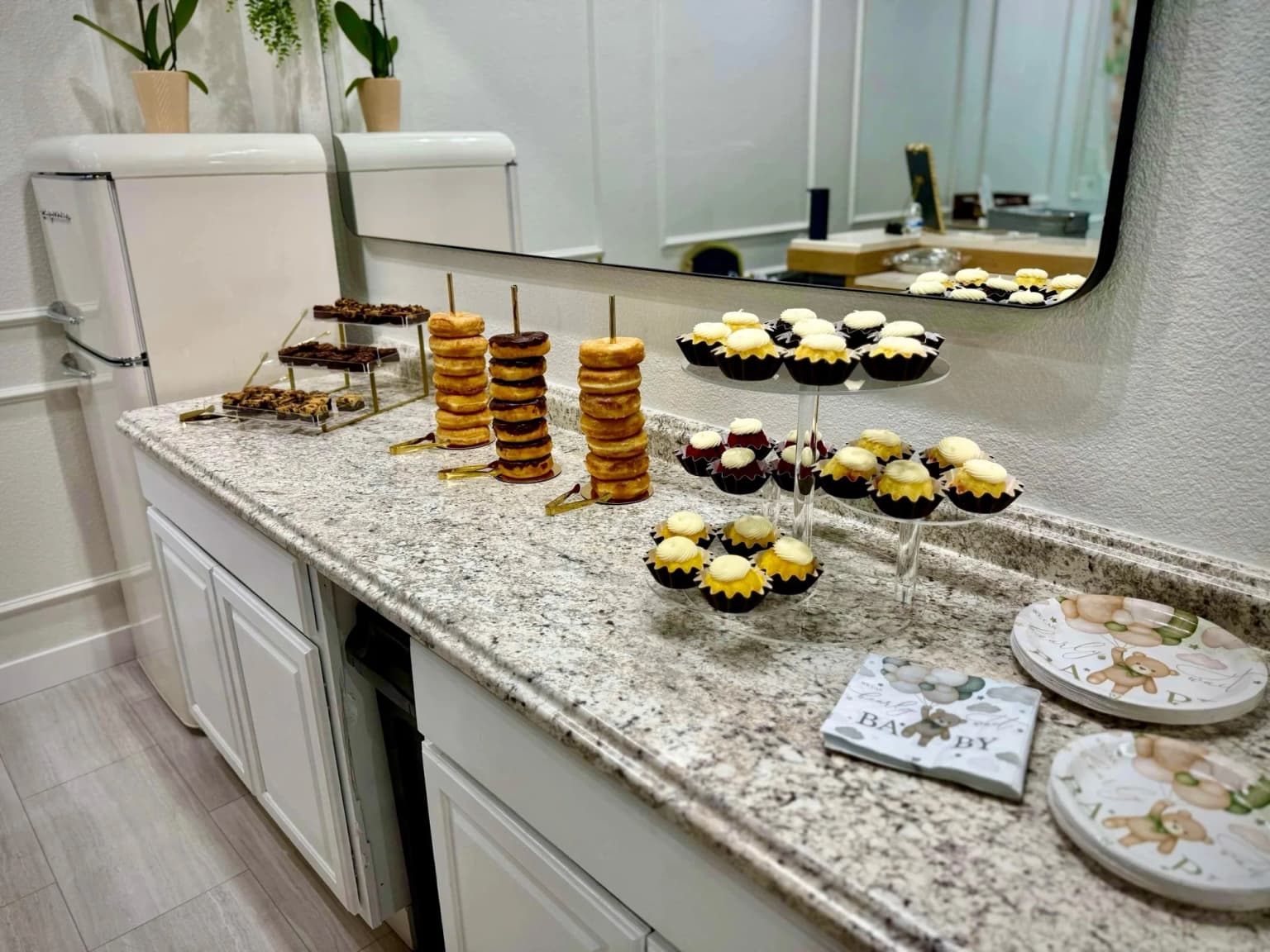 Dessert display with cupcakes and treats for a baby shower at Aramas Events