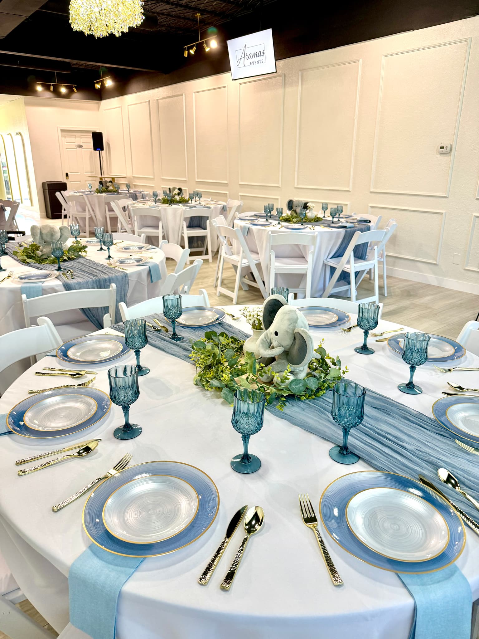 Baby shower table detail with blue place settings and elephant centerpiece at Aramas Events
