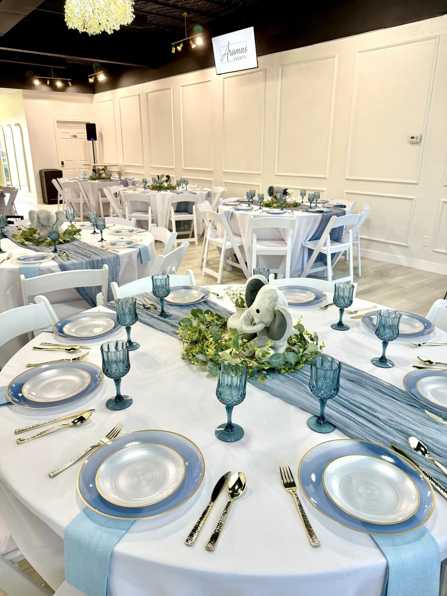 Baby shower table detail with blue place settings and elephant centerpiece at Aramas Events
