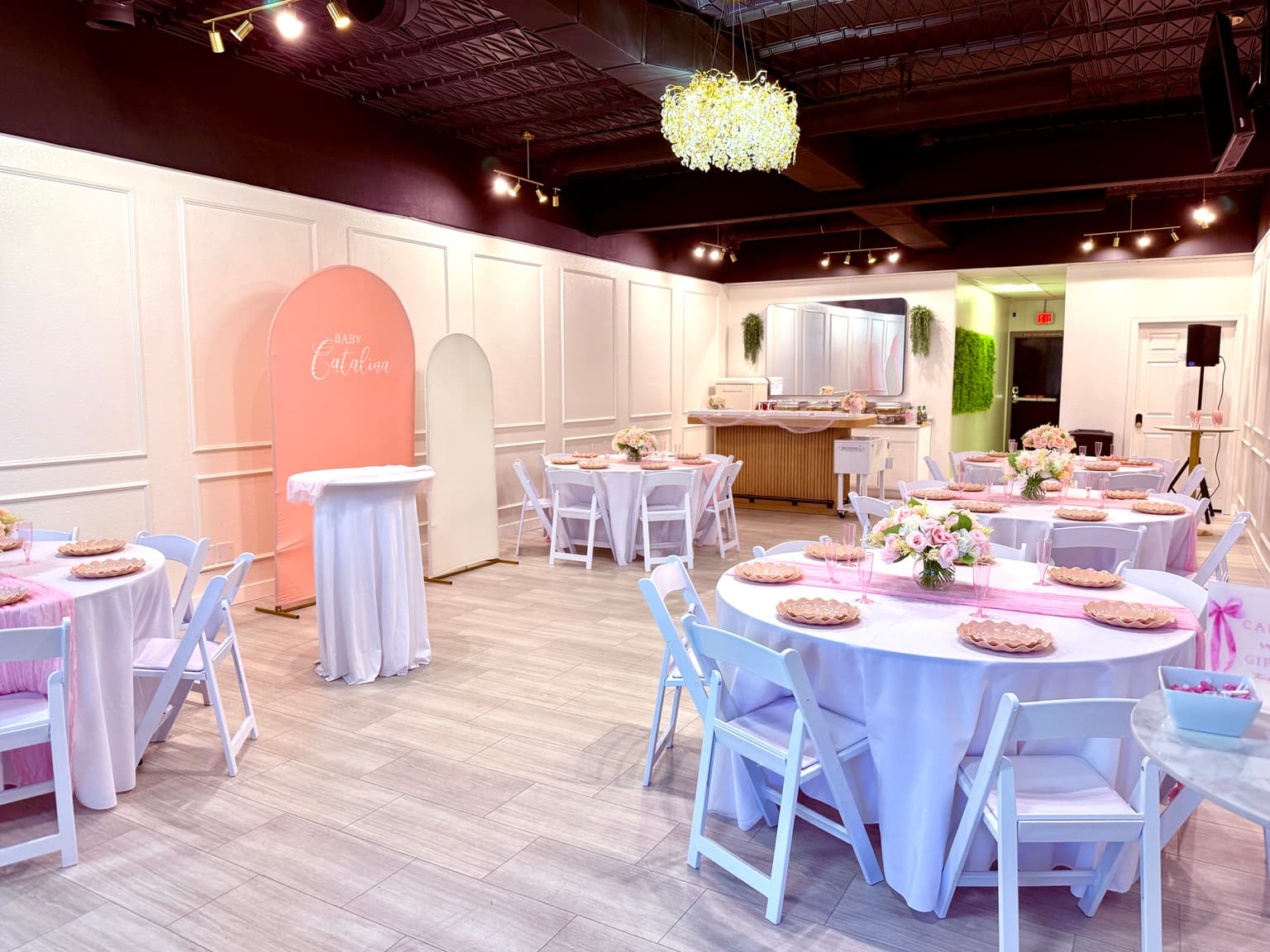 Pink girls baby shower room setup with round tables and soft pink decor at Aramas Events