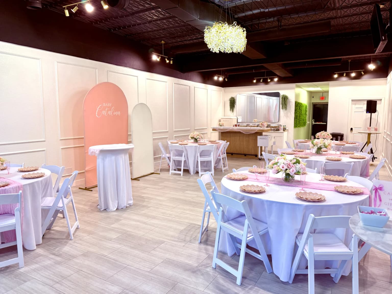 Pink girls baby shower room setup with round tables and soft pink decor at Aramas Events