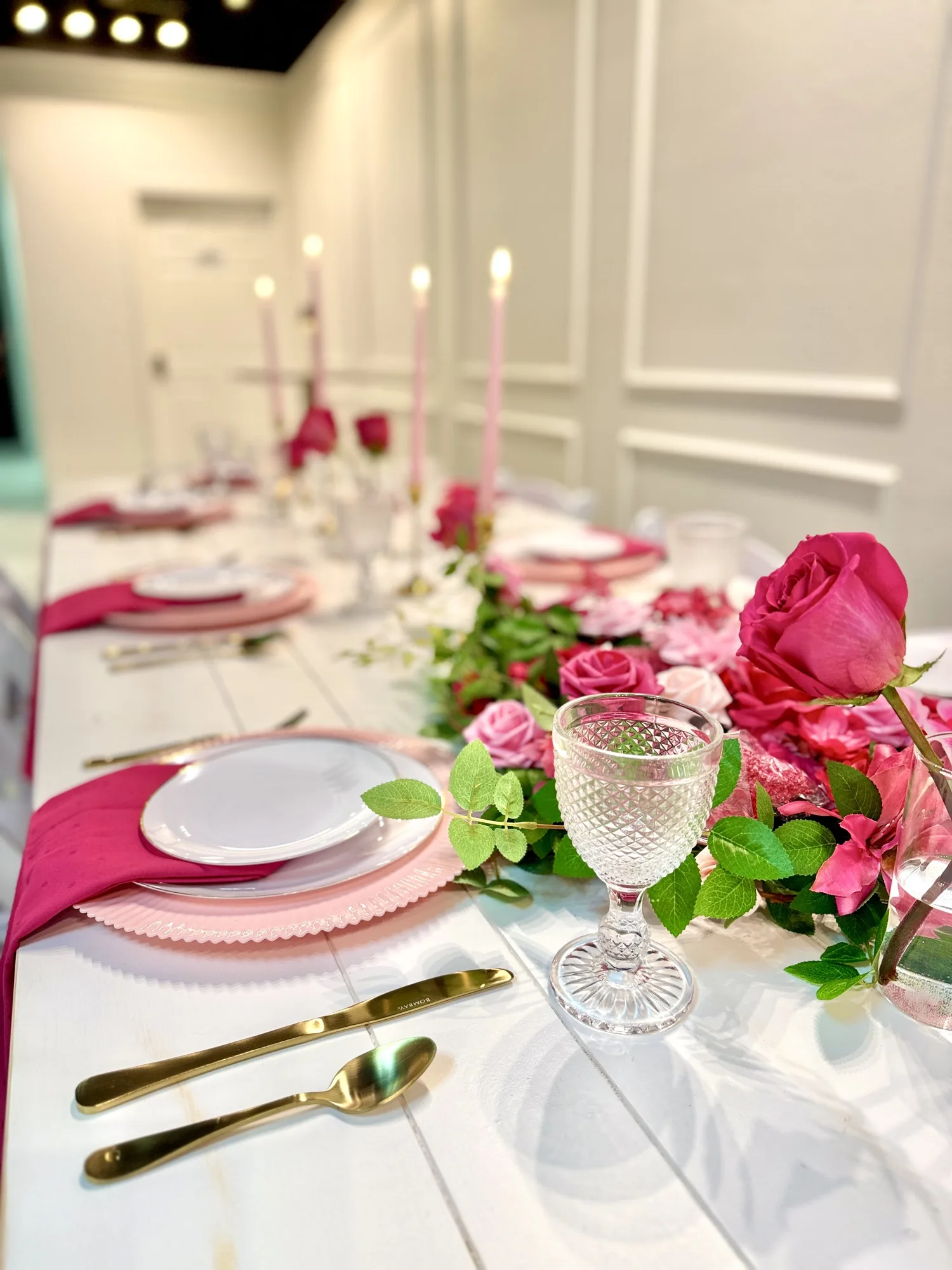 Pink floral table setting with candles and place settings at Aramas Events