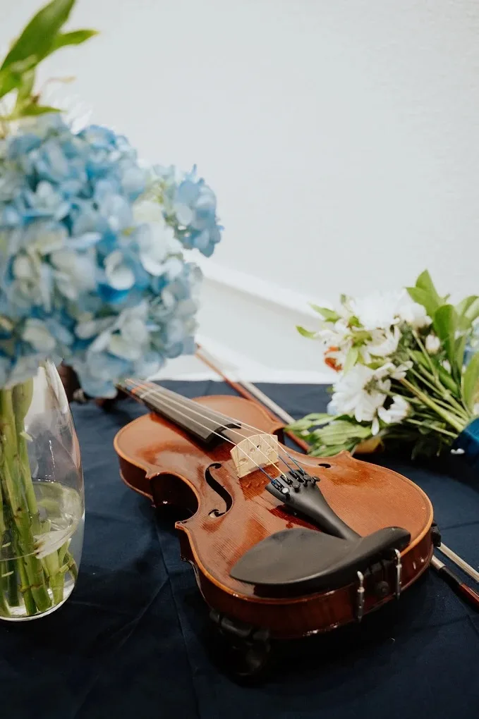 Violin with blue and white floral wedding decor at Aramas Events